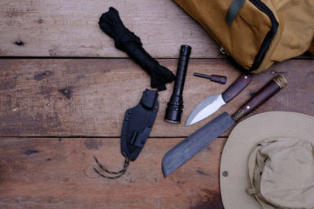 A knife with equipment for survival in the forest  on an old wooden floorの写真素材