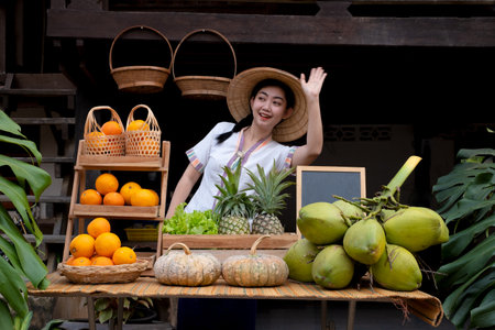 Indigenous Asian women waving to greet tourists with a natural assortment of fruits welcome tourists at the farm stay. Homestay in Thailandの写真素材