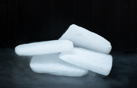 Dry ice cubes stacked on black backgroundの写真素材