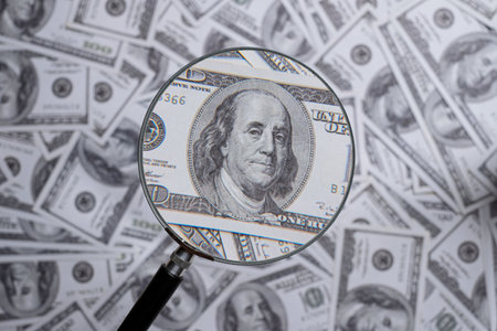 Hundred us dollar bill through magnifying lens checking banknotesの写真素材