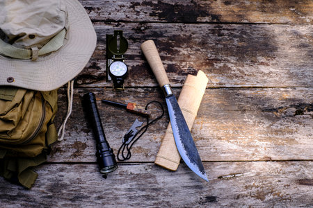 Knife backpack with equipment for survival in the forest on the old wooden backgroundの写真素材