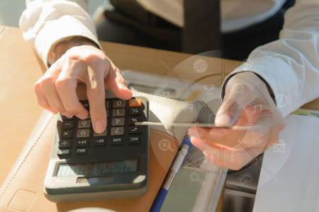 businessman working with calculator and credit card on wooden desk in modern office with virtual...