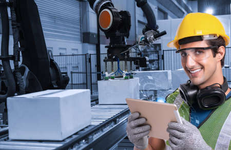 Engineer hand using tablet, heavy automation robot arm machine in smart factory industrial with...