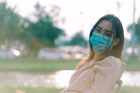 Asian teenager teen girl young woman wearing a face mask outside during the Coronavirus COVID-19 virus pandemicの写真素材
