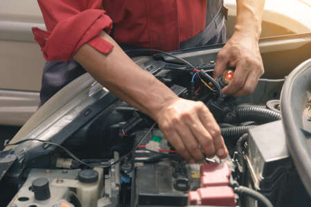 Mechanic repairs car in a car repair stationの写真素材