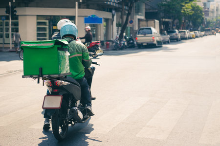 Food delivery drivers are driving to deliver products to customers who order online. Impact of epidemicsの写真素材