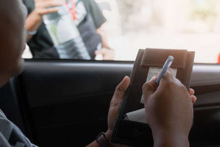 Man writing on slip credit card opening fuel tank of his old car,copy spaceの写真素材