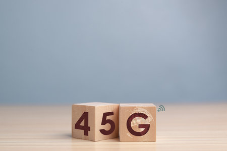 Symbol of the change from 4G to 5G. Changed wooden blocks from 4G to 5G. Technology, network, communication concept. Beautiful brown table, blue background, copy space.の写真素材