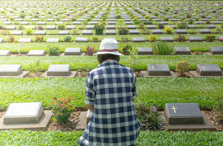 Woman sitting at grave,Sad woman is mourning for dead person at grave in cemetery.の写真素材