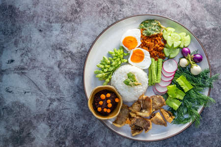 Spicy Rice Salad with Deep fried Gourami Fish Served Chili, onion and carved vegetable Thai Food Fusion Style topview, copy space for text.の写真素材