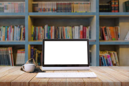 Laptop with a cup of fresh coffee latte art on wooden table in library or coffee shop E-learning concept.の写真素材