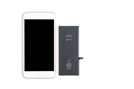 The battery is next to the phone. The process of replacing the battery in a cell phone on white or...