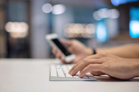 Businessman using a social media marketing concept on keyboard computer with notification icons of ove, chat, message and comment above computer keyboard.の写真素材