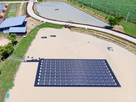 Solar panels farm between agriculture fields in aerial view. in Thailandの写真素材