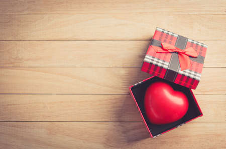 gift box with a red heart inside on a white old wooden table. Valentine day, copy space for text.の写真素材