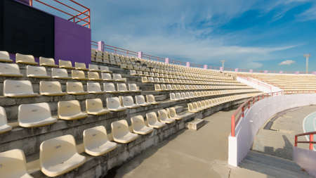 stadium, red seats on stadium steps bleacher with spot light pole, copy space for text.の写真素材