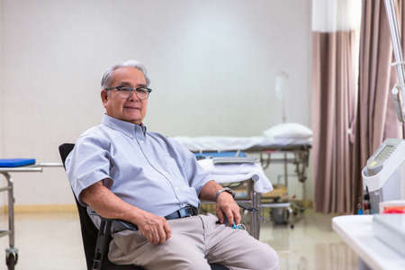 Happy optimistic senior 70s man looking at camera with smile during appointment at doctor office. Portrait of elder male patient in background. Medic careの写真素材