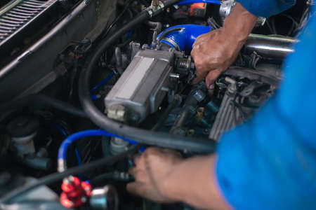 Auto mechanic working in garage. Repair service.の写真素材