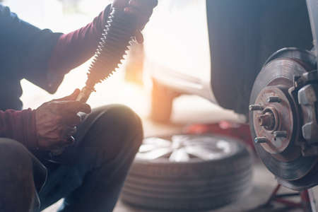 Selective focus disc brake on car, in process of new tire replacement,Car brake repairing in garageの写真素材