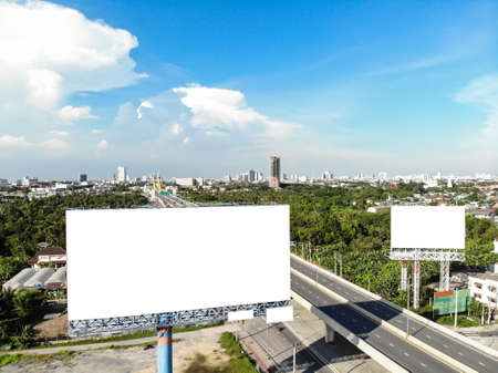 Blank white road billboard with Bangkok cityscape background at day time. Street advertising poster, Side view. The concept of marketing communication to promote or sell idea, copy space for text.の写真素材