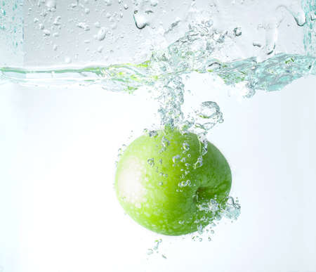 Fresh apples falling into water with splashes, copy space for text.の写真素材