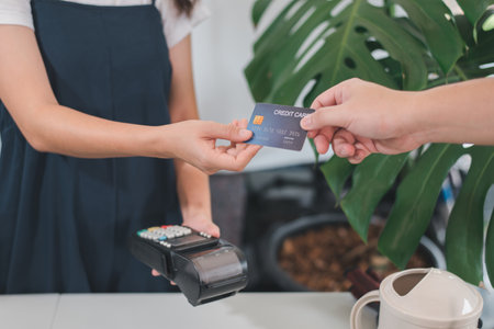 Customer using credit card for payment to owner at cafe restaurant, cashless technology and credit...