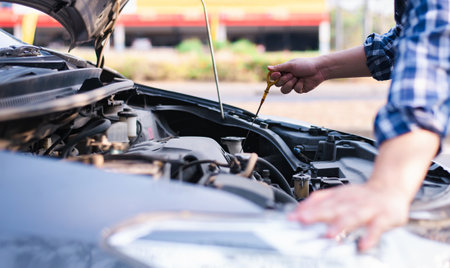 The hand of the male mechanic examined the amount of engine oil. additionally, engine readiness prior to departure, engineer concepts, and auto maintenanceの写真素材