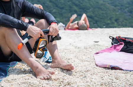 beach adventure, young man holding snorkeling gear and a mask on the beach ,summer anr travel conceptの写真素材