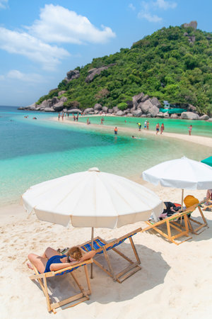 Teen girl taking in the view of the ocean seated near the water in a beach chair,travel vacation concept.の写真素材