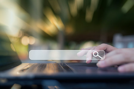 People use laptops or computers to look for information on the internet utilizing the copyspace and search box icons.の写真素材