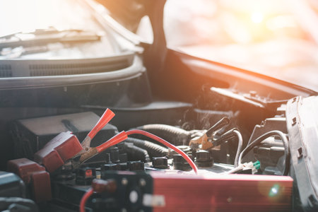 Car and battery charger in auto repair business,Auto mechanic working in garage. Repair service.の写真素材