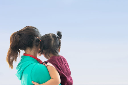 embracing a mother and a daughter, A lovely young girl embraces her mother.の写真素材