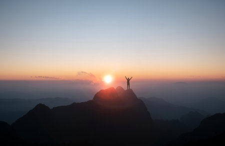 Male hiker surrounded by the splendor of nature, arms extended.の写真素材