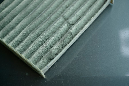 Close-up view of a used, dirty air filter, emphasizing the need for regular maintenance.