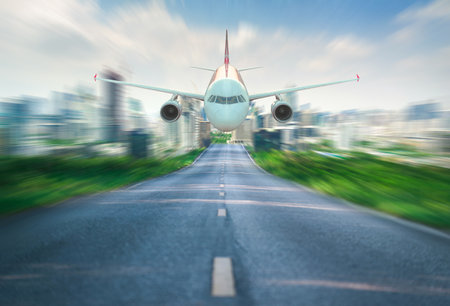 A jet airplane appears to be flying low over a rapidly blurred city road, creating a sense of speed and urgency.の写真素材