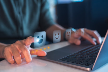 Close-up of a hand selecting a happy face and five stars on a digital feedback interface, symbolizing customer satisfaction and online reviews.の写真素材