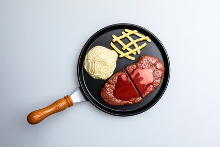 Heart shape in a frying pan on a white background, top viewの写真素材