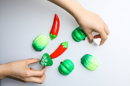 Hands decorating chocolate candies with red and green peppers.の写真素材