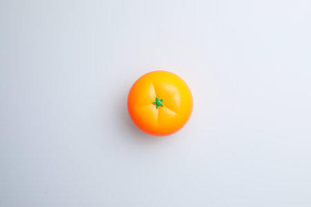 Orange candle on a white background, top view, copy space.の写真素材
