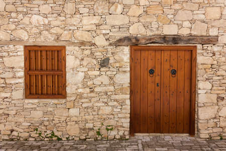 Ancient door and windows on a stone wallの写真素材