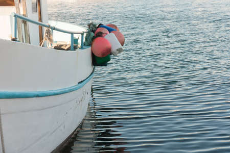 White boat side with a blue line tied at dock with blue seaの写真素材