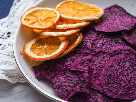 Slices of dried fruit and oranges on the white plate.