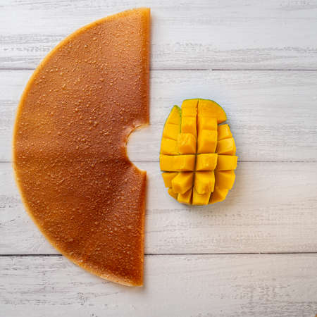 Colorful mango fruit leather and fresh mango on light backgroundの写真素材