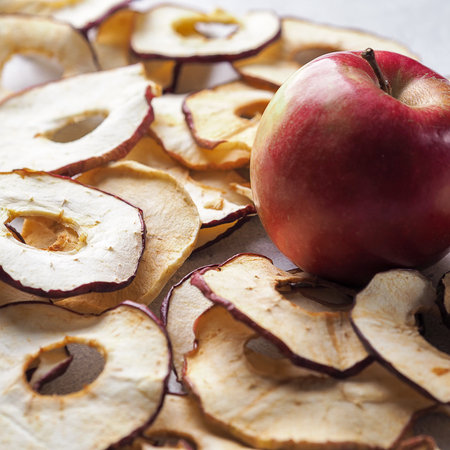 Sliced dried apples ready to eat on a wooden table and fresh apple . Top viewの写真素材