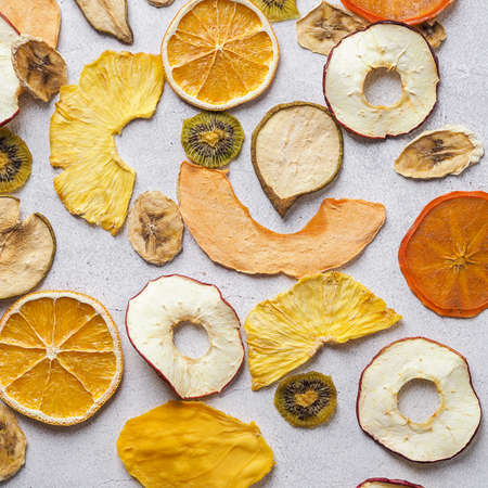 Flatlay of assorted Colorful Dried Fruits. Persimmon, pear. apple, melon, pineapple, kiwi and orange on white background.の写真素材