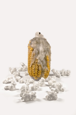 Candle on corn with popcorn around on white backgroundの写真素材
