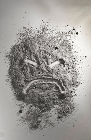 Angry emoticon made of grey ashの写真素材