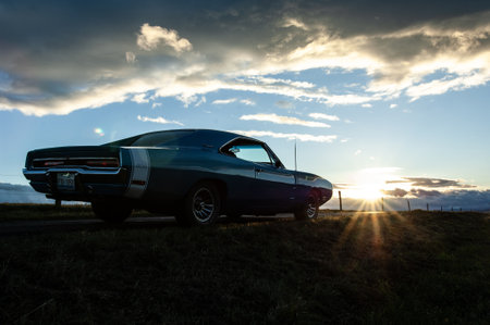 Classic american car at sunset with dramatic sky and sun rays.のeditorial素材