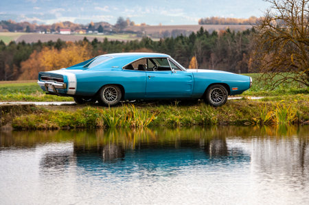 Classic american car on the road at sunset, motion blur. Dodge Charger 500 1970