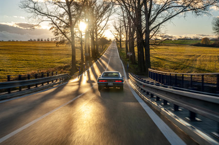 Classic american car on the road at sunset, motion blur. Dodge Charger 500 1970